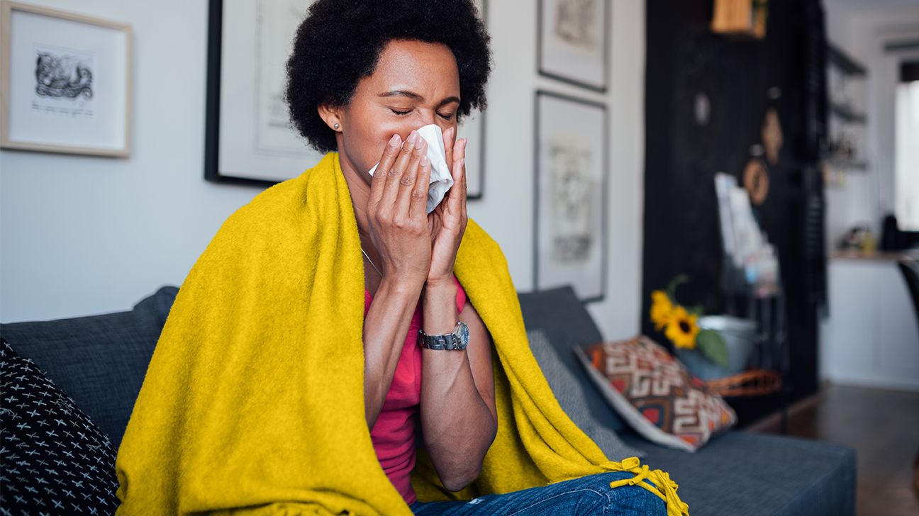 Woman sneezing, unsure if it's cold vs. allergies